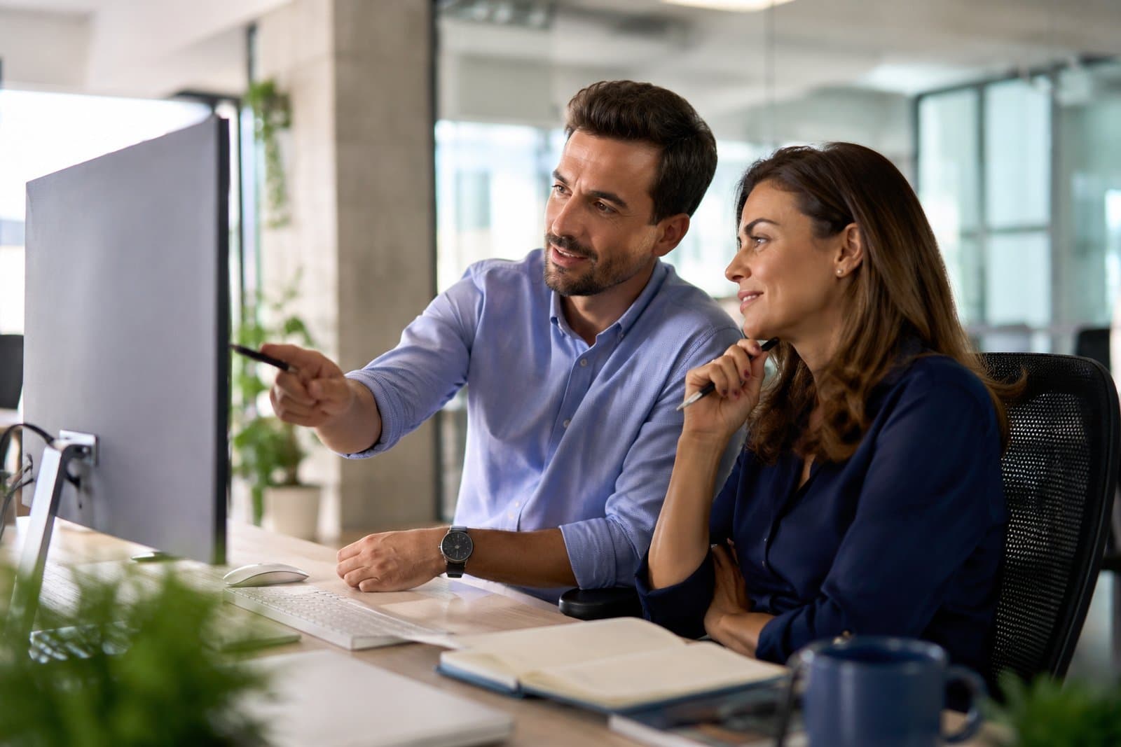 Dos profesionales revisando el envío de registros en un monitor